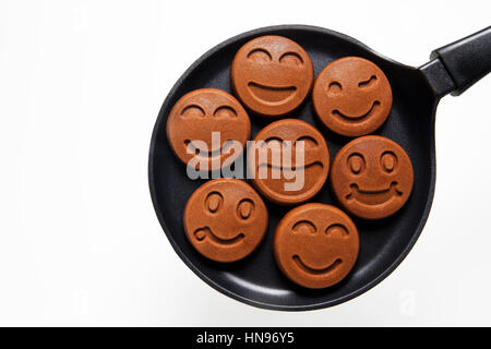 funny smiling Chocolat Pancakes in the pan. Concept of Happy Food. Stock Photo