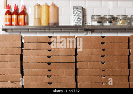 Pizzas cardboard boxes for shipping and delivery. a lot of packaging is on the kitchen stock Stock Photo
