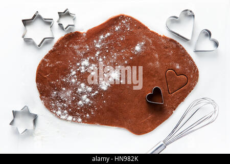 dough for chocolate cookies  and cookie cutters in the shape of hearts and stars. whisk. on white Stock Photo