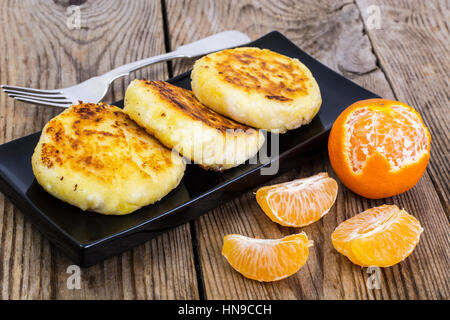 Hot sweet cheesecakes with tangerines and honey Stock Photo