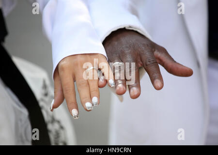 Causian and African-American couple holding hand with ring Stock Photo