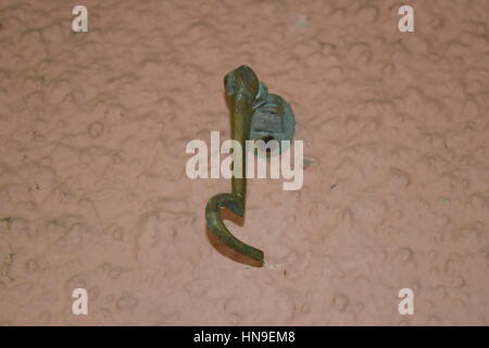 Gold plated door hook hanging from the wall Stock Photo