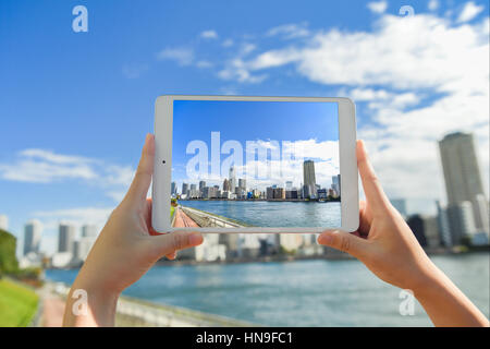 Japanese woman using augumented reality app on tablet downtown Tokyo, Japan Stock Photo