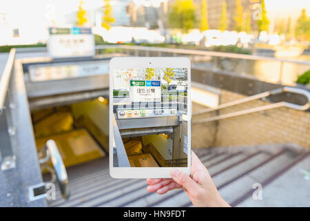 Japanese woman using augumented reality app on tablet downtown Tokyo, Japan Stock Photo