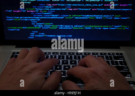 Man typing code on laptop computer Stock Photo