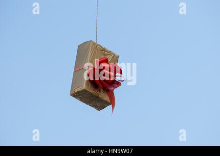 Gift boxes that hang suspended on wires and networks. Street decorations before Christmas, New Year and Valentine's Day. Stock Photo