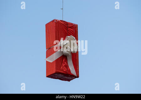 Gift boxes that hang suspended on wires and networks. Street decorations before Christmas, New Year and Valentine's Day. Stock Photo