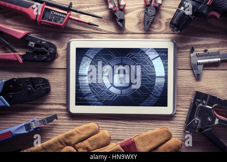 Tablet pc with security concept on screen and industrial tools around Stock Photo