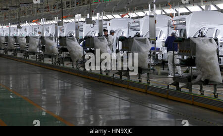 Tianjin, China. December 17th 2016: Workers assemble a car on assembly line in car factory Stock Photo