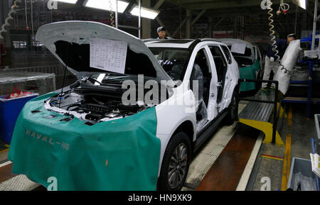 Tianjin, China. December 17th 2016: Workers assemble a car on assembly line in car factory Stock Photo