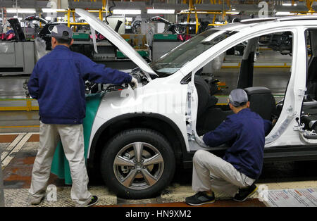 Tianjin, China. December 17th 2016: Workers assemble a car on assembly line in car factory Stock Photo