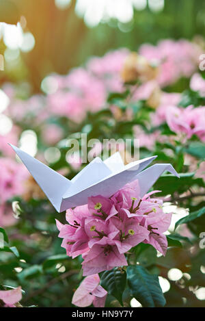 white paper crane on flower branch of tree Stock Photo