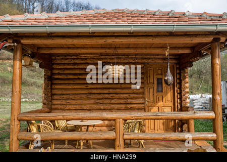 Porch on the houses made of logs of wood with garden furniture of bamboo Stock Photo