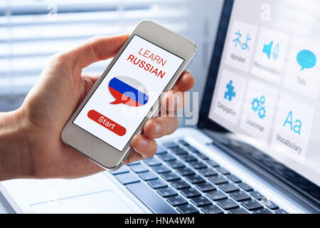 Learn Russian language online concept with a person showing e-learning app on mobile phone with the flag of Russia Stock Photo