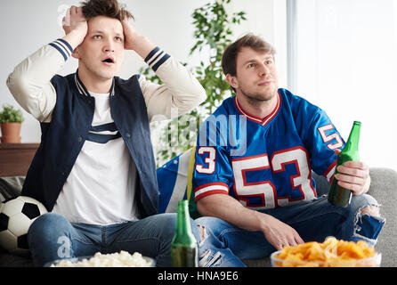 Two young adults men watching soccer game Stock Photo