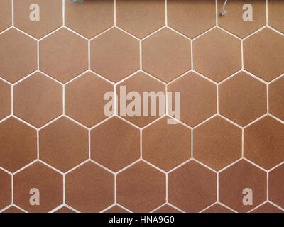 Wall tiled with brown hexagonal ceramic tiles Stock Photo