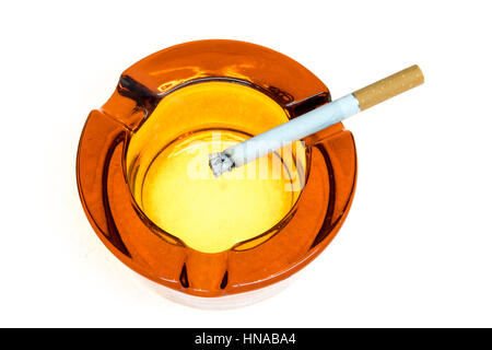 Cigarette in a glass ashtray isolated on white Stock Photo