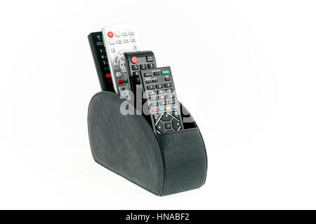 Remote controllers in leather holder isolated on white background Stock Photo