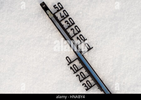 Thermometer on snow shows low temperatures in degrees Celsius Stock Photo