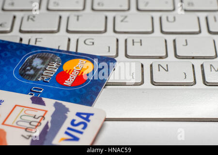 Sarajevo, Bosnia and Herzegovina - January 25 , 2017: closeup pile of credit cards, Visa payWawe and MasterCard, credit, debit. On laptop keyboard. Stock Photo