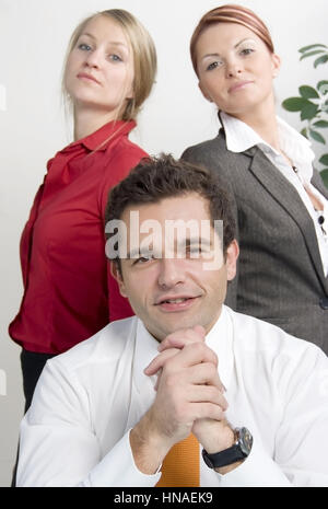 Junger geschaeftsmann mit zwei huebschen Sekretaerinnen - young business man with two attractive secretaries Stock Photo