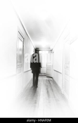 Man in black, motion blur, walking in a white hospital coooridor. Stock Photo