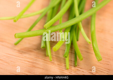 bunch of fresh chives close up on a wooden table - selective focus Stock Photo