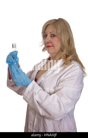 female doctor or nurse with gloved hands in a white lab coat drawing up medication from a vial with a 40 unit per milliliter syringe Stock Photo