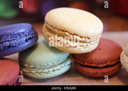 Macaroon dessert with colored fillings lie on a wooden table Stock Photo