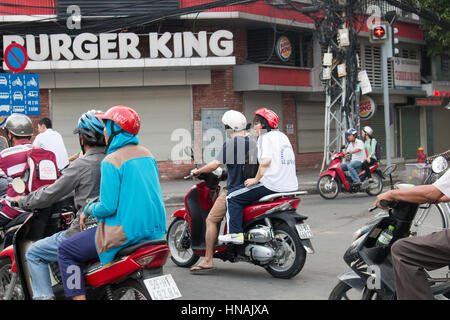 Scooter motorbike riders travelling through Ho Chi Minh city in Vietnam,Asia Stock Photo