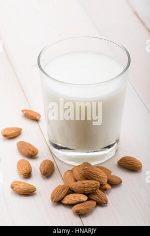 glass of milk with almonds on wooden table Stock Photo