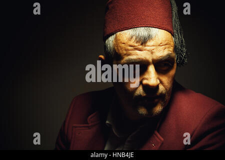 Traditional clothe style from Macedonia, Bosnia or Serbia, portrait of an adult man wearing red fez cap an jacket. Stock Photo