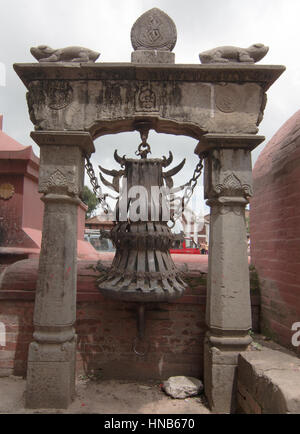 Stylised brass bell outside a Hindu temple in Bhaktapur, Kathmandu, used  for religious ceremonies Stock Photo