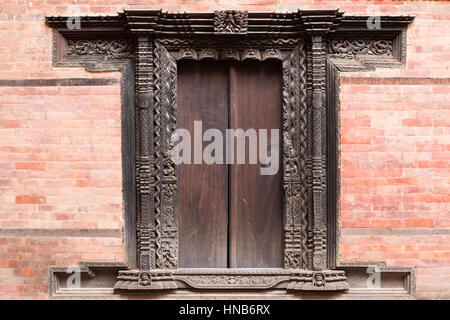 Richly carved jambs in the traditional Nepali style of a wooden doorway adorn an old building in Bhaktapur, Kathmandu Stock Photo