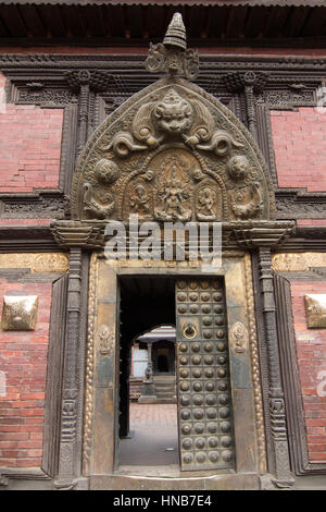 Ornately carved lintel of a traditional Nepalese-style wooden doorway in Bhaktapur, Kathmandu Stock Photo