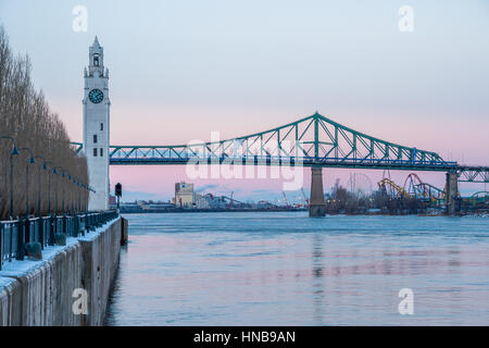 Montreal, CA - 5 February 2017: Montreal Clock Tower and Jacques Cartier Bridge in Winter, after sunset Stock Photo