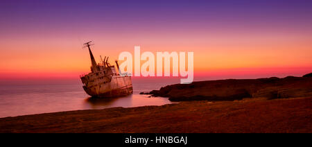 Seascape: famouse boat, shipwrecked near the rocky shore at the sunset. Mediterranean, near Paphos. Cyprus. Stock Photo