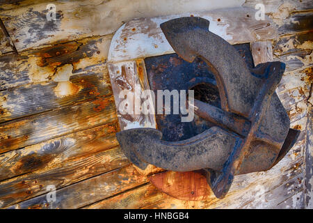 close up of an old rusty boat anchor on a weathered boat Stock Photo