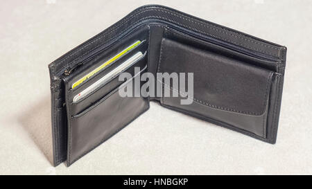 An open black leather wallet with credit cards. Light background. Stock Photo