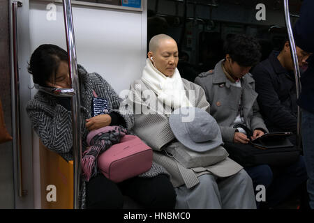 Asian people, Korean woman, commuters napping while traveling on a subway train in Seoul, South Korea, Asia. Railway, transportation Stock Photo