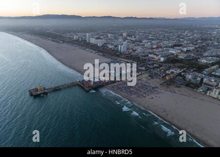 Santa Monica, California, USA - July 21, 2016:  After sunset twilight aerial of large crowd gathered at the Santa Monica pier near Los Angeles. Stock Photo