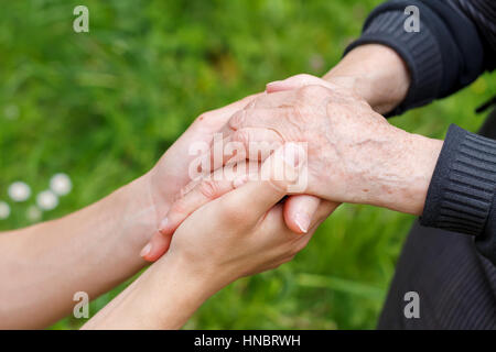 Doctor's hand holding a wrinkled elderly hand Stock Photo