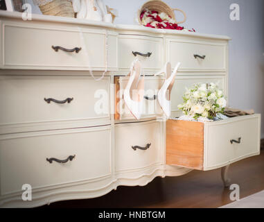 Wedding shoes and bouquet on a dresser Stock Photo