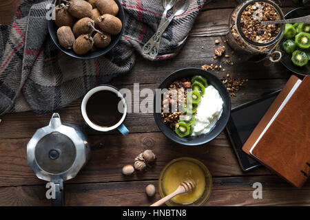 Granola, kiwi fruit and yogurt with coffee Stock Photo