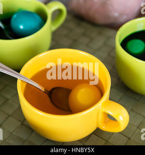Cups with eggs and colored dye for Easter Stock Photo