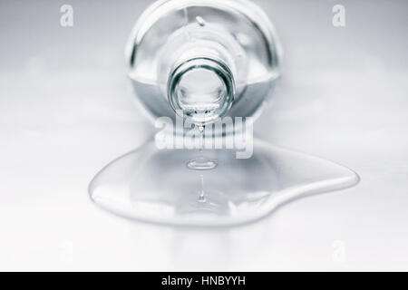 Bottle lying on table with water coming out Stock Photo