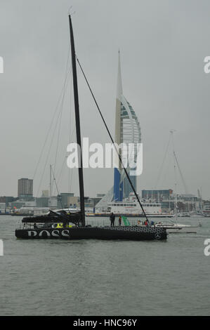 Alex Tomson arriving in Gosport in England after being the runner up in the Vendee Globe round the world yacht race with flotilla of small boats and large crowd on the shore side Stock Photo