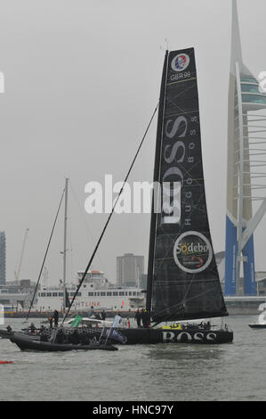 Alex Tomson arriving in Gosport in England after being the runner up in the Vendee Globe round the world yacht race with flotilla of small boats and large crowd on the shore side Stock Photo