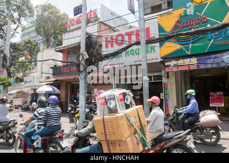 Scooter motorbike riders travelling through Ho Chi Minh city in Vietnam,Asia Stock Photo