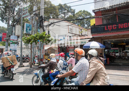 Scooter motorbike riders travelling through Ho Chi Minh city in Vietnam,Asia Stock Photo